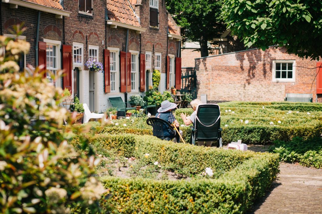 Maison et jardin avec personnes âgées qui discutent